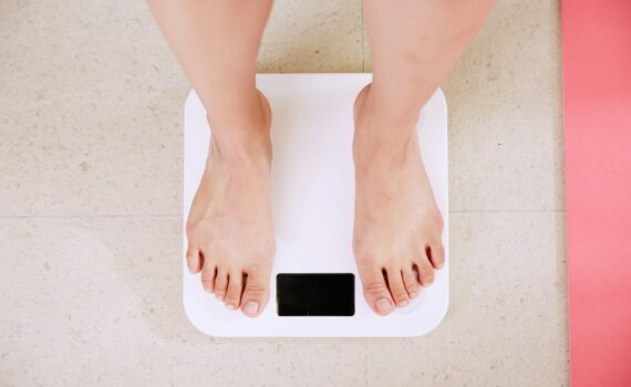 person standing on white digital bathroom scale